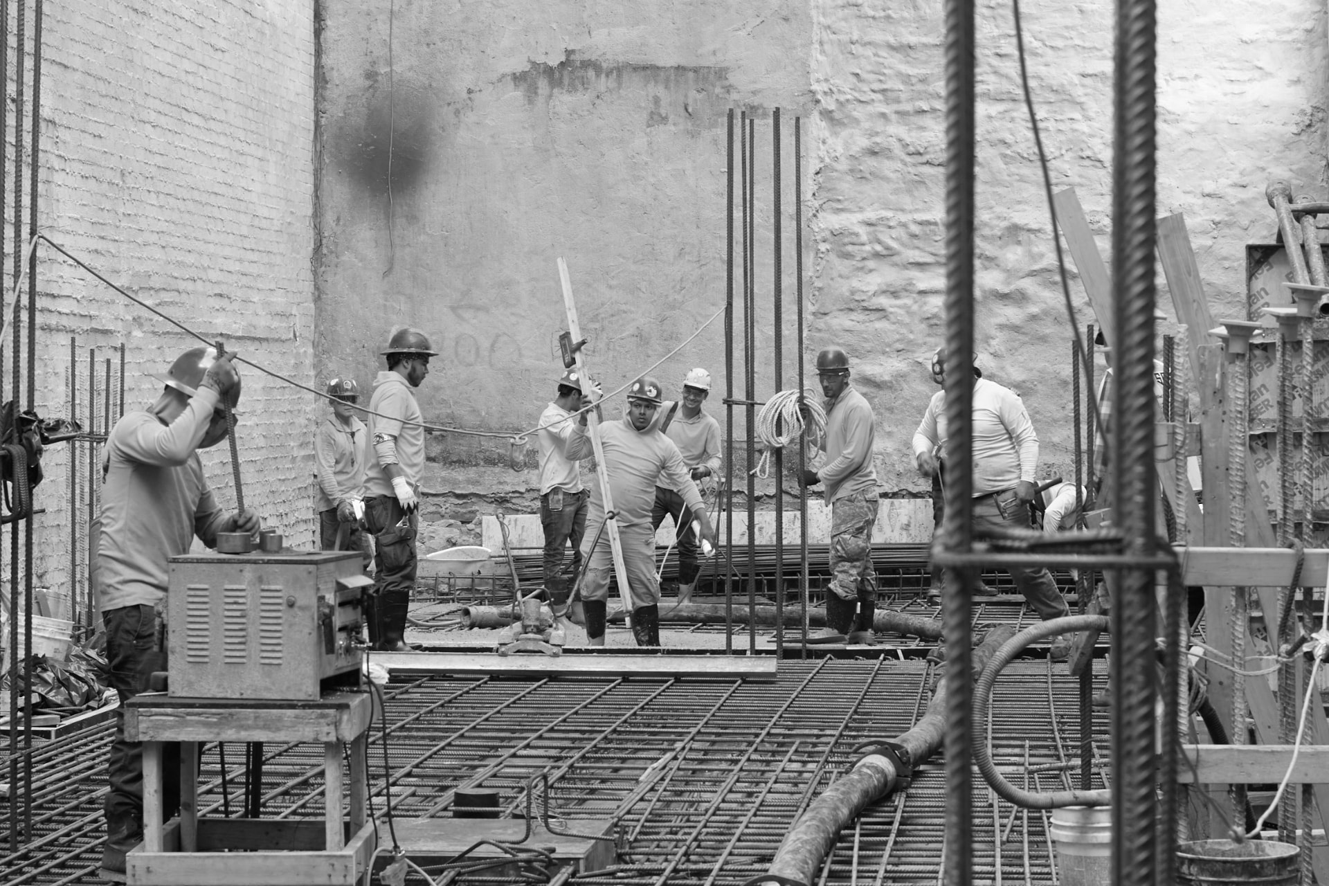 Crew coordinating a concrete pour over a mat foundation
